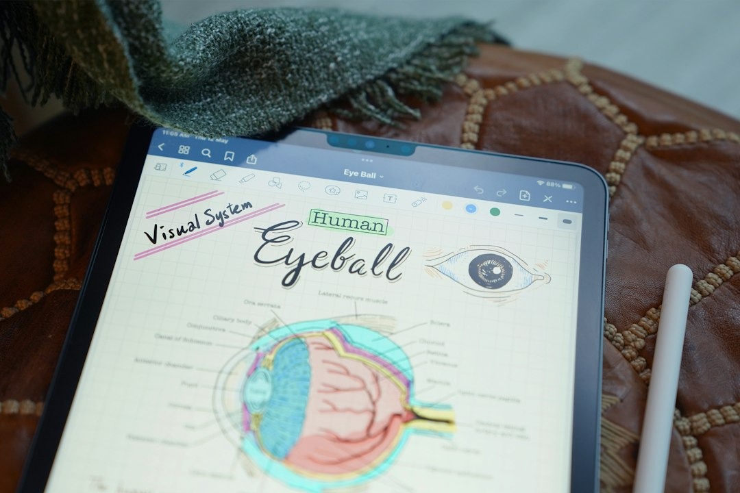 Tablet shows anatomical diagram of an eyeball with handwritten notes.